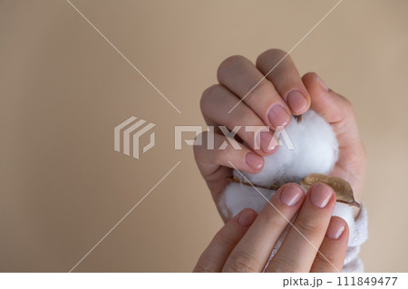Pastel softness manicured nails on neutral beige background. Woman showing her new manicure in colors of pastel palette. Simplicity decor fresh spring vibes earth-colored neutral tones  111849477
