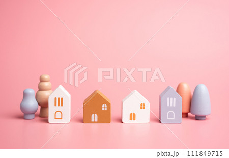 Houses and figures, children toys. Buying a home, searching for rent. Investments in real estate. Figures of houses and trees in a small neighborhood. Safety and integrity. 111849715
