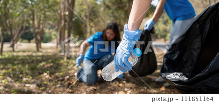 Volunteer collecting plastic trash in the forest. The concept of environmental conservation. Global environmental pollution. Cleaning the forest Volunteer collecting plastic trash in the forest. The concept of environmental conservation. Global environmental pollution. Cleaning the forest 111851164