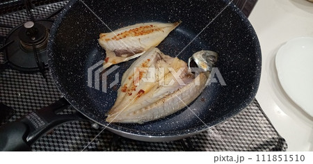アジの干物をフライパンで焼く 111851510