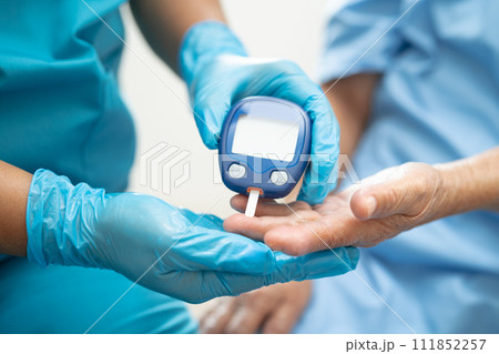 Doctor check diabetes from finger blood sugar level with finger lancet. 111852257