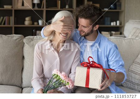 Loving grownup son makes pleasant surprise for mother on birthday 111853727