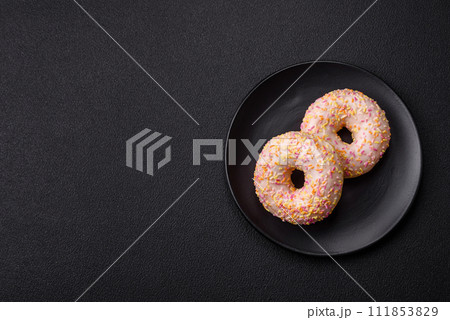 Delicious sweet bright donuts with cream on a plain background Delicious sweet bright donuts with cream on a plain background 111853829