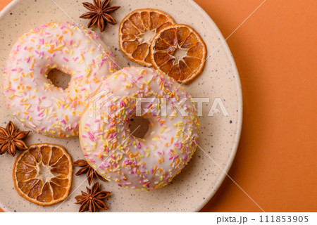 Delicious sweet bright donuts with cream on a plain background 111853905