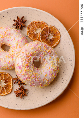 Delicious sweet bright donuts with cream on a plain background 111853906