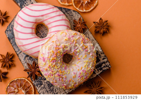 Delicious sweet bright donuts with cream on a plain background 111853929