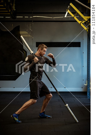 Boxer practicing punches with barbell for explosive strength at gym 111854184