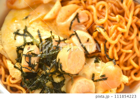 fried yakisoba Japanese noodles and cabbage topping egg and sausage dressing seaweed in sauce on bowl  111854223
