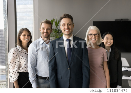Happy colleagues of different ages standing behind young male leader Happy colleagues of different ages standing behind young male leader 111854473