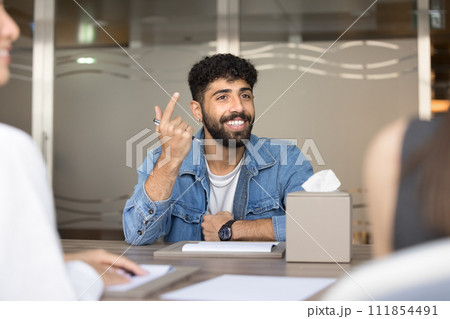 Cheerful handsome Arab entrepreneur man speaking to business partners 111854491