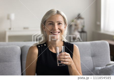 Portrait of smiling woman holding glass of fresh pure water Portrait of smiling woman holding glass of fresh pure water 111854585