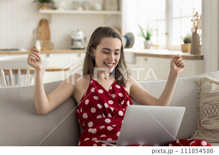 Happy young woman relish great, unbelievable on-line news 111854586