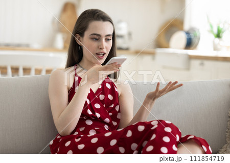 Young pretty woman talking to boyfriend on speaker phone 111854719