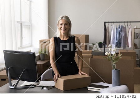 Portrait of happy mature businesswoman posing in warehouse office 111854782