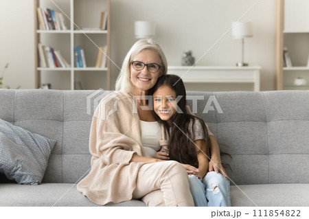 Happy positive granny and cute granddaughter girl hugging with love 111854822