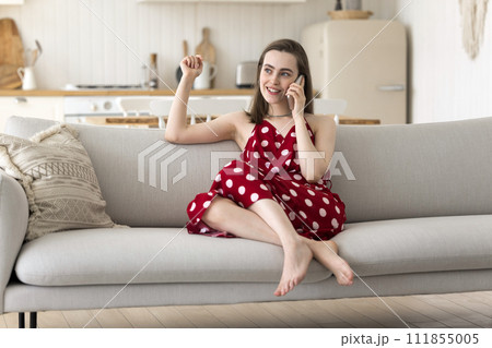 Carefree young woman talking on smart phone 111855005