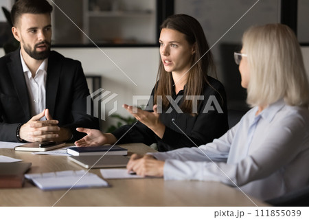 Serious pretty project manager talking to coworkers on brainstorming meeting Serious pretty project manager talking to coworkers on brainstorming meeting 111855039