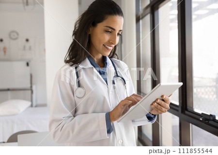 Positive practitioner woman working in clinic office with tablet Positive practitioner woman working in clinic office with tablet 111855544