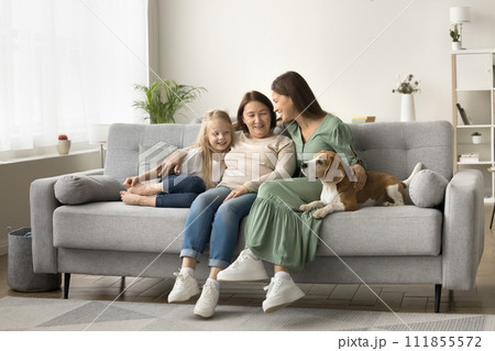 Wide family home portrait of three female generations with dog 111855572