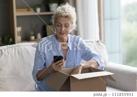 Positive mature woman hold cellphone use express transportation logistic service Positive mature woman hold cellphone use express transportation logistic service 111855931