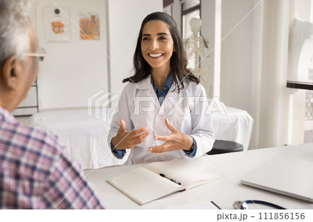 Happy young Latin practitioner woman giving consultation to old patient 111856156