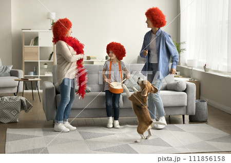 Active girl, mom, grandma in red wigs dancing with dog 111856158