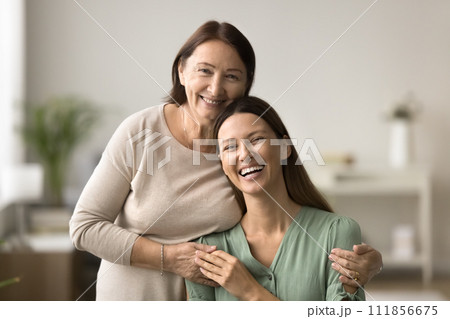 Happy senior mom hugging beautiful young daughter from behind 111856675