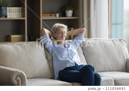 Silent peaceful middle-aged woman relaxing on sofa, take daytime break Silent peaceful middle-aged woman relaxing on sofa, take daytime break 111856691