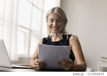 Smiling business woman hold papers read good news Smiling business woman hold papers read good news 111856825