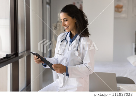 Happy young doctor woman reading medical records, getting report Happy young doctor woman reading medical records, getting report 111857028
