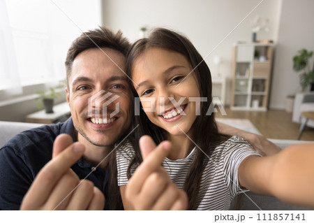 Happy handsome dad and adorable daughter kid showing finger hearts Happy handsome dad and adorable daughter kid showing finger hearts 111857141