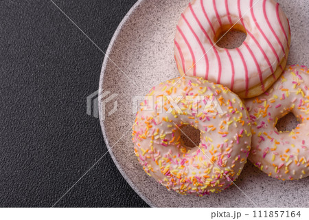Delicious sweet bright donuts with cream on a plain background 111857164
