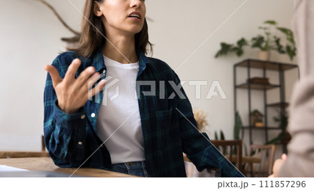 Serious young professional woman in informal clothes talking to colleague Serious young professional woman in informal clothes talking to colleague 111857296