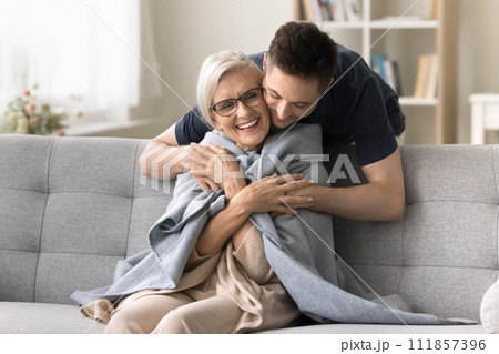 Positive adult son man caring for happy elderly mature mother Positive adult son man caring for happy elderly mature mother 111857396