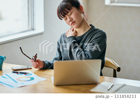 デスクワークで肩が凝る若い女性 111858211
