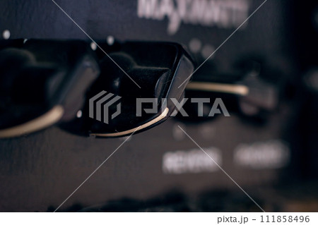 Knobs on Guitar Amplifier closeup, macro photo Knobs on Guitar Amplifier closeup, macro photo 111858496