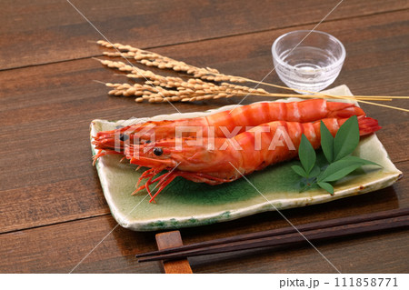 お皿に盛り付けた大海老の姿焼き_日本酒添え 111858771