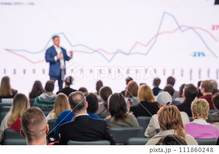 Confident speaker at business conference presenting growth charts 111860248