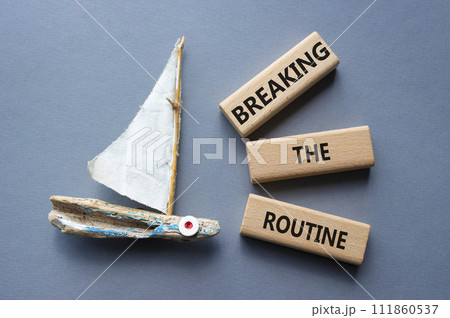 Breaking the Routine week symbol. Concept words Breaking the Routine on wooden blocks. Beautiful grey background with boat. Business and Breaking the Routine concept. Copy space 111860537