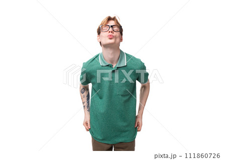 young bright ginger man with a tattoo on his arm dressed in a green short-sleeved T-shirt sends an young bright ginger man with a tattoo on his arm dressed in a green short-sleeved T-shirt sends an 111860726