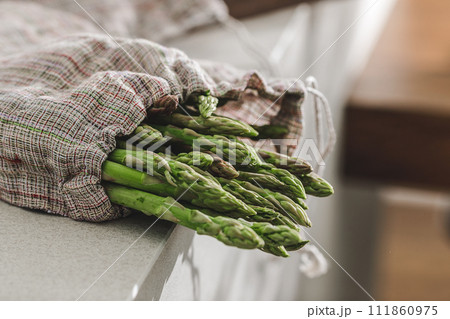 fresh green asparagus in linen bag. Kitchen aesthetic concept fresh green asparagus in linen bag. Kitchen aesthetic concept 111860975