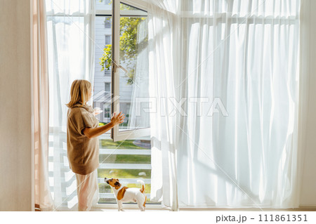 Peaceful relaxed mature woman enjoying morning fresh air and cup of coffee. Happy thoughtful 50s lady relaxing at open window, planning day. drinking hot beverage. Peaceful relaxed mature woman enjoying morning fresh air and cup of coffee. Happy thoughtful 50s lady relaxing at open window, planning day. drinking hot beverage. 111861351