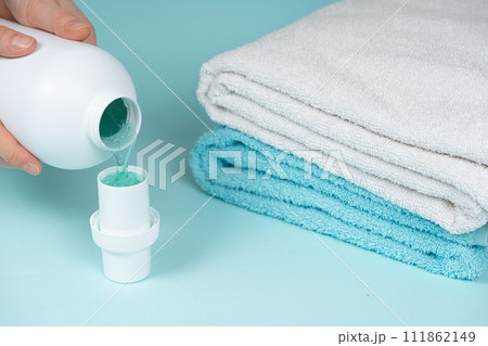 The process of pouring natural eco gel liquid laundry detergent from the bottle into the cap The process of pouring natural eco gel liquid laundry detergent from the bottle into the cap 111862149