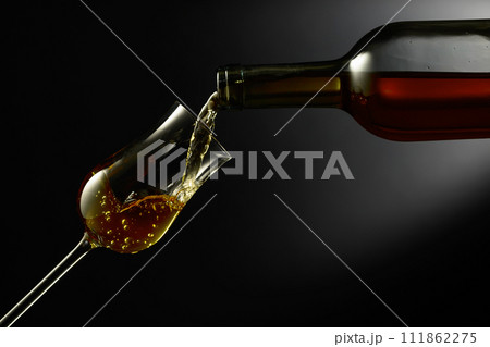 Glass of premium alcohol on a black background. 111862275