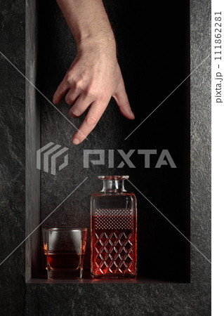 Hand reach for a decanter of whiskey. 111862281