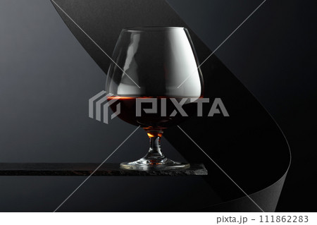 Snifter of brandy on a black background. Snifter of brandy on a black background. 111862283