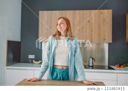 Woman with crossed hands standing behind countertop looking at the camera Woman with crossed hands standing behind countertop looking at the camera 111862913