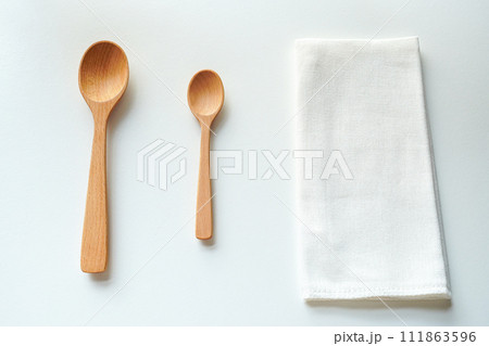 白背景の上の木のスプーンと白いガーゼの布巾 111863596