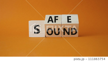 Safe and Sound symbol. Turned wooden cubes with words Safe and Sound. Beautiful orange background. Business and Safe and Sound concept. Copy space 111863754
