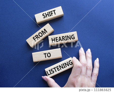 Listening symbol. Wooden blocks with words Shift from Hearing to Listening. Businessman hand. Beautiful deep blue background. Business and Listening concept. Copy space. Listening symbol. Wooden blocks with words Shift from Hearing to Listening. Businessman hand. Beautiful deep blue background. Business and Listening concept. Copy space. 111863825